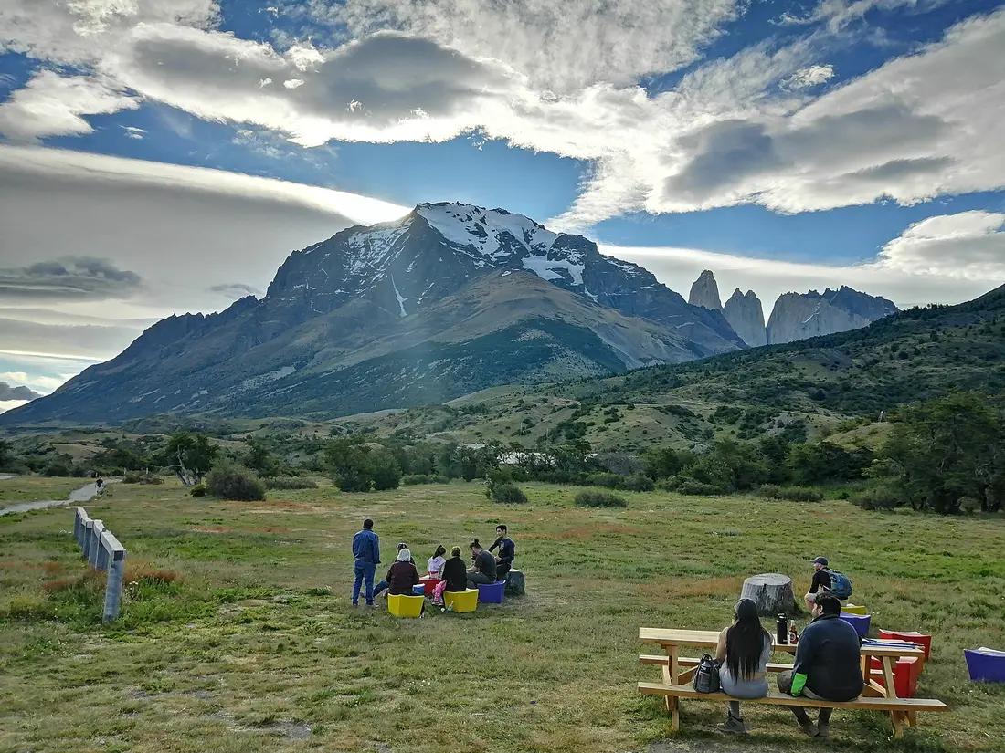 Grupo descansando en un campamento al atardecer con las Torres de fondo